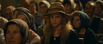 Movie still from “Manon of the Spring” (1986), directed by Claude Berri – A woman with a hat is in a crowd of people; Close Up shot, High angle