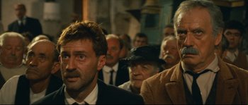 Movie still from “Manon of the Spring” (1986), directed by Claude Berri – A group of people standing in a room; Close Up shot, Low angle