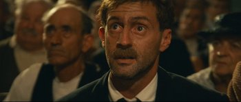 Movie still from “Manon of the Spring” (1986), directed by Claude Berri – A person wearing a suit and tie; Close Up shot, Low angle