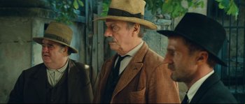 Movie still from “Manon of the Spring” (1986), directed by Claude Berri – An older man wearing a suit and a hat; Medium shot, Over the shoulder angle