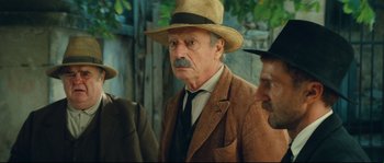 Movie still from “Manon of the Spring” (1986), directed by Claude Berri – An older man wearing a hat and a suit; Close Up shot, Over the shoulder angle