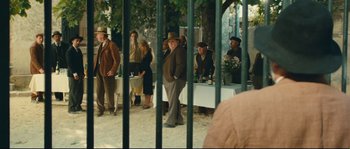 Movie still from “Manon of the Spring” (1986), directed by Claude Berri – A group of people standing next to each other near a tree; Wide shot, Over the shoulder angle