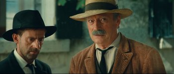 Movie still from “Manon of the Spring” (1986), directed by Claude Berri – An older man wearing a straw hat and a suit; Close Up shot, Over the shoulder angle