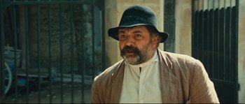 Movie still from “Manon of the Spring” (1986), directed by Claude Berri – An older man wearing a hat and a jacket; Close Up shot, Low angle