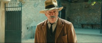 Movie still from “Manon of the Spring” (1986), directed by Claude Berri – An old man wearing a hat and a suit; Close Up shot, Low angle