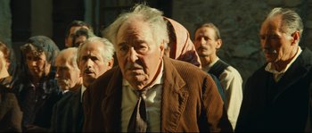 Movie still from “Manon of the Spring” (1986), directed by Claude Berri – An old man in a brown jacket and a brown tie; Close Up shot, Over the shoulder angle