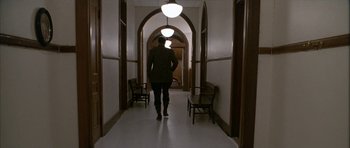 Movie still from “Map of the Human Heart” (1992), directed by Vincent Ward – A man walking down a hallway in a building; Wide shot, Low angle