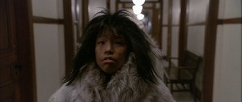 Movie still from “Map of the Human Heart” (1992), directed by Vincent Ward – A person wearing a fur coat with long hair on top of their head; Close Up shot, Low angle