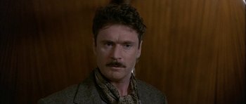 Movie still from “Map of the Human Heart” (1992), directed by Vincent Ward – A person wearing a suit and tie; Close Up shot, Low angle