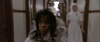 Movie still from “Map of the Human Heart” (1992), directed by Vincent Ward – A person wearing a fur coat in a room; Close Up shot, Over the shoulder angle
