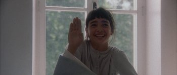 Movie still from “Map of the Human Heart” (1992), directed by Vincent Ward – A young girl holding her hand up in the air; Close Up shot, Over the shoulder angle