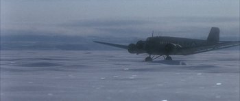 Movie still from “Map of the Human Heart” (1992), directed by Vincent Ward – An airplane is flying low in the sky; Extreme Wide shot, High angle