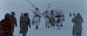 Movie still from “Map of the Human Heart” (1992), directed by Vincent Ward – A group of people in snow suits carrying skis; Wide shot, Low angle