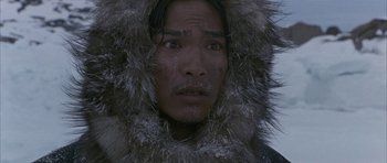 Movie still from “Map of the Human Heart” (1992), directed by Vincent Ward – A man in a fur coat is looking at the camera; Close Up shot, High angle