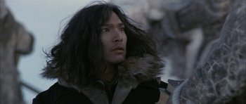 Movie still from “Map of the Human Heart” (1992), directed by Vincent Ward – A man with long black hair wearing a black jacket; Close Up shot, Low angle