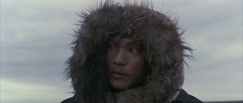 Movie still from “Map of the Human Heart” (1992), directed by Vincent Ward – A man in a fur coat is looking into the distance; Close Up shot, High angle