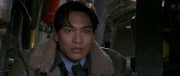 Movie still from “Map of the Human Heart” (1992), directed by Vincent Ward – A person wearing a coat and tie; Close Up shot, High angle