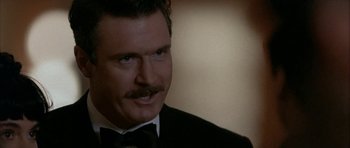 Movie still from “Map of the Human Heart” (1992), directed by Vincent Ward – A person wearing a suit and tie; Close Up shot, Low angle