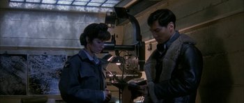 Movie still from “Map of the Human Heart” (1992), directed by Vincent Ward – A man and a woman standing next to each other in a room; Medium shot, High angle