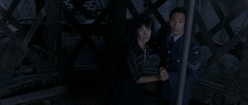 Movie still from “Map of the Human Heart” (1992), directed by Vincent Ward – A man and a woman holding hands in a dark room; Medium shot, Overhead angle