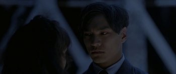 Movie still from “Map of the Human Heart” (1992), directed by Vincent Ward – A man in a suit and tie looking into the distance; Close Up shot, Over the shoulder angle