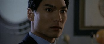 Movie still from “Map of the Human Heart” (1992), directed by Vincent Ward – A person wearing a suit and tie; Close Up shot, Low angle