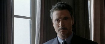 Movie still from “Map of the Human Heart” (1992), directed by Vincent Ward – A person wearing a suit and tie; Close Up shot, Low angle