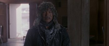 Movie still from “Map of the Human Heart” (1992), directed by Vincent Ward – A man wearing a fur hat and a black jacket; Medium shot, Over the shoulder angle