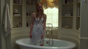 Movie still from “Maps to the Stars” (2014), directed by David Cronenberg – A woman in a white dress standing in front of a bath tub; Medium shot, Low angle