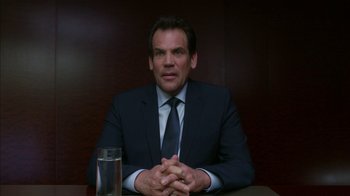 Movie still from “Maps to the Stars” (2014), directed by David Cronenberg – A man in a suit and tie sitting at a table; Medium shot, Low angle