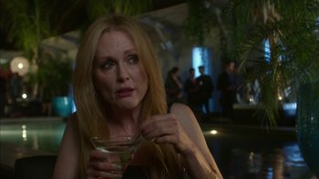 Movie still from “Maps to the Stars” (2014), directed by David Cronenberg – A woman sitting at a table holding a drink; Close Up shot, Over the shoulder angle