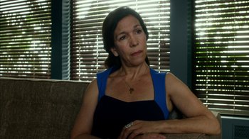 Movie still from “Maps to the Stars” (2014), directed by David Cronenberg – A person sitting on a couch near a window; Close Up shot, Over the shoulder angle