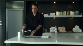Movie still from “Maps to the Stars” (2014), directed by David Cronenberg – A man in a black shirt is in a kitchen; Medium shot, Low angle
