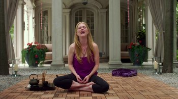 Movie still from “Maps to the Stars” (2014), directed by David Cronenberg – A woman sitting on the ground with her eyes closed; Medium shot, High angle