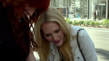 Movie still from “Maps to the Stars” (2014), directed by David Cronenberg – A woman leaning on another woman on the sidewalk; Close Up shot, High angle