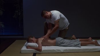 Movie still from “Maps to the Stars” (2014), directed by David Cronenberg – A man getting a massage from another man on the floor; Medium shot, Low angle