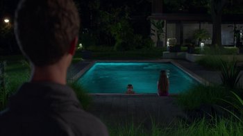 Movie still from “Maps to the Stars” (2014), directed by David Cronenberg – A man and a woman sitting in a pool at night; Wide shot, Over the shoulder angle