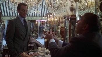 Movie still from “Marathon Man” (1976), directed by John Schlesinger – Two men in suits are sitting at a dining table; Medium shot, Over the shoulder angle