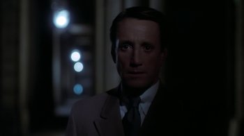Movie still from “Marathon Man” (1976), directed by John Schlesinger – A man wearing a suit and tie standing in front of a window; Close Up shot, Over the shoulder angle