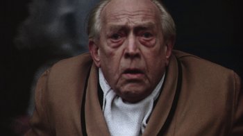 Movie still from “Marathon Man” (1976), directed by John Schlesinger – An old man wearing a brown jacket and a white shirt; Close Up shot, Low angle