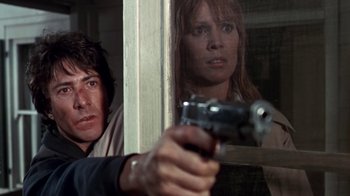 Movie still from “Marathon Man” (1976), directed by John Schlesinger – A man and a woman holding a gun in front of a window; Close Up shot, Low angle