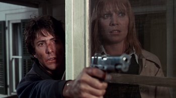 Movie still from “Marathon Man” (1976), directed by John Schlesinger – A man and a woman holding a gun in front of a window; Close Up shot, Low angle