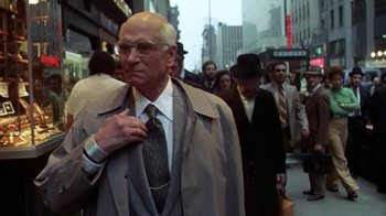 Movie still from “Marathon Man” (1976), directed by John Schlesinger – An older man in a suit and tie standing in a crowd; Medium shot, Low angle