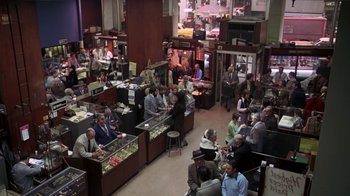 Movie still from “Marathon Man” (1976), directed by John Schlesinger – A group of people sitting around a store; Extreme Wide shot, High angle