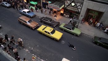 Movie still from “Marathon Man” (1976), directed by John Schlesinger – An aerial view of a city street with cars and a person lying on the ground; Extreme Wide shot, Overhead angle