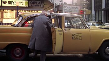 Movie still from “Marathon Man” (1976), directed by John Schlesinger – A man standing next to an open door of a taxi cab; Wide shot, Low angle