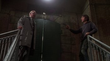 Movie still from “Marathon Man” (1976), directed by John Schlesinger – Two men in suits are standing next to each other; Wide shot, Low angle