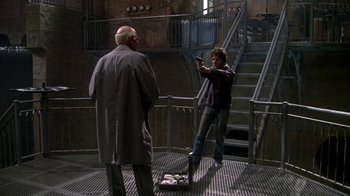 Movie still from “Marathon Man” (1976), directed by John Schlesinger – Two men are standing in an industrial setting; Wide shot, Low angle