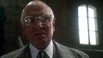 Movie still from “Marathon Man” (1976), directed by John Schlesinger – An older bald man wearing glasses and a tie; Close Up shot, Low angle