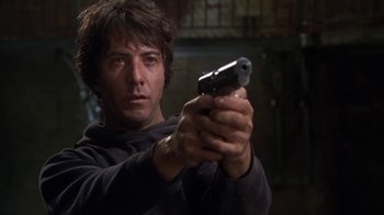 Movie still from “Marathon Man” (1976), directed by John Schlesinger – A man is holding a gun in his hand; Close Up shot, Low angle